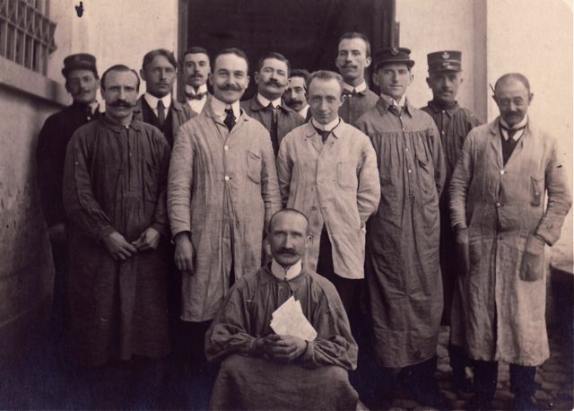De mannen van de post stellen fier hun zelfontworpen uniform voor.